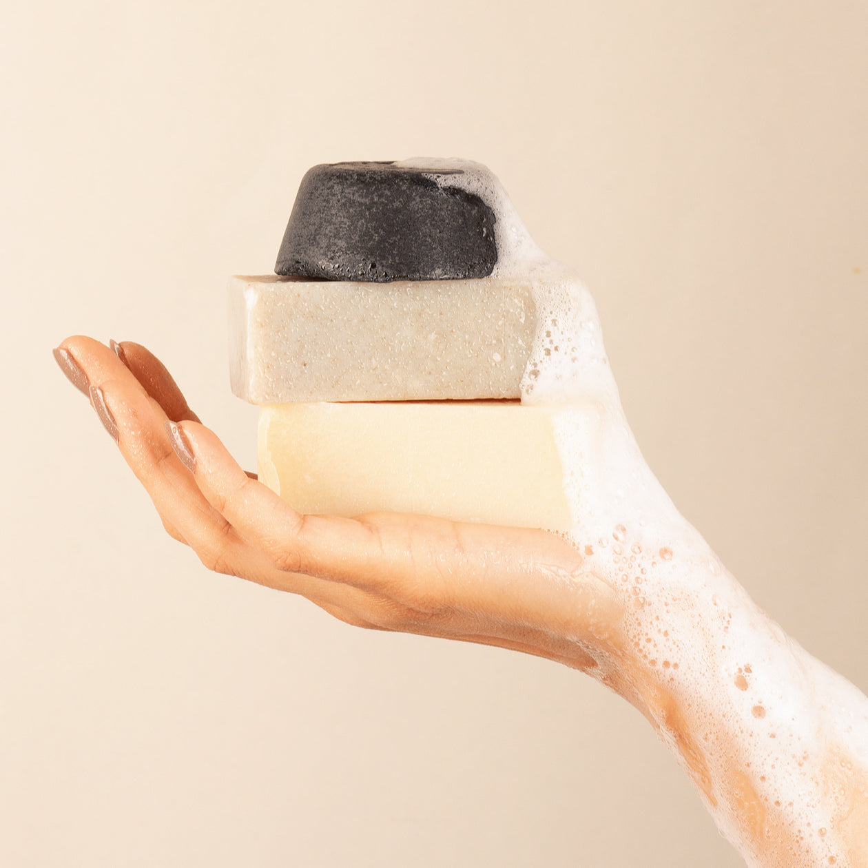 soaps and exfoliator being held in the air